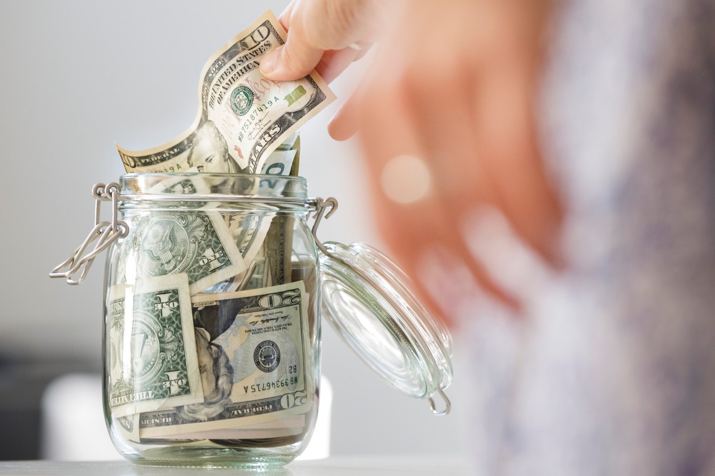 BERLIN, GERMANY - AUGUST 14: A hand puts a dollar bill in a Moneybox on August 14, 2015, in Berlin, Germany. (Photo by Thomas Trutschel/Photothek via Getty Images)