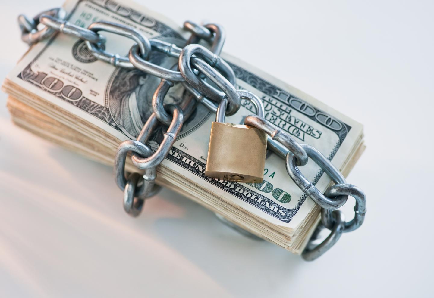 Money wrapped with lock and chain