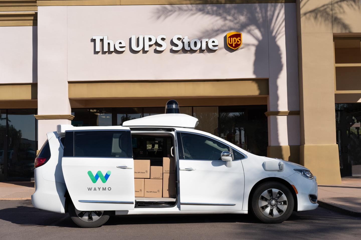 a waymo van in front of a UPS store