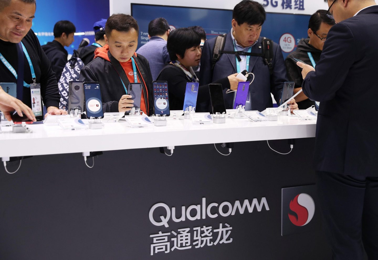 People look at 5G smartphones at Qualcomm booth during the 2nd China International Import Expo (CIIE) at the National Exhibition and Convention Center on November 7, 2019 in Shanghai, China.