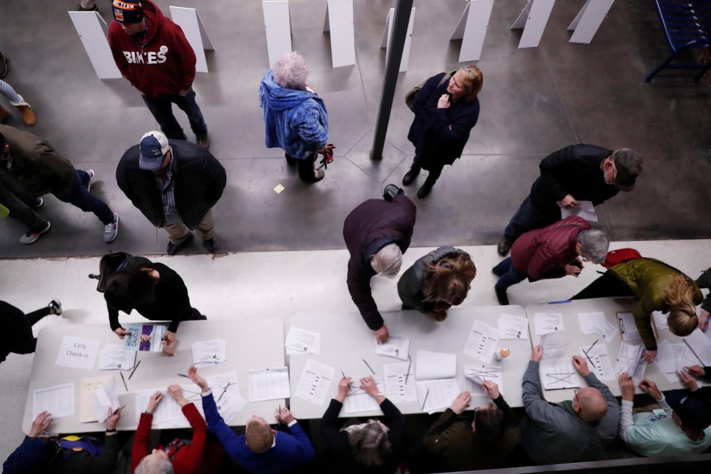 Caucus goers check in at a caucus at Roosevelt High School, Feb. 3, 2020, in Des Moines, Iowa.