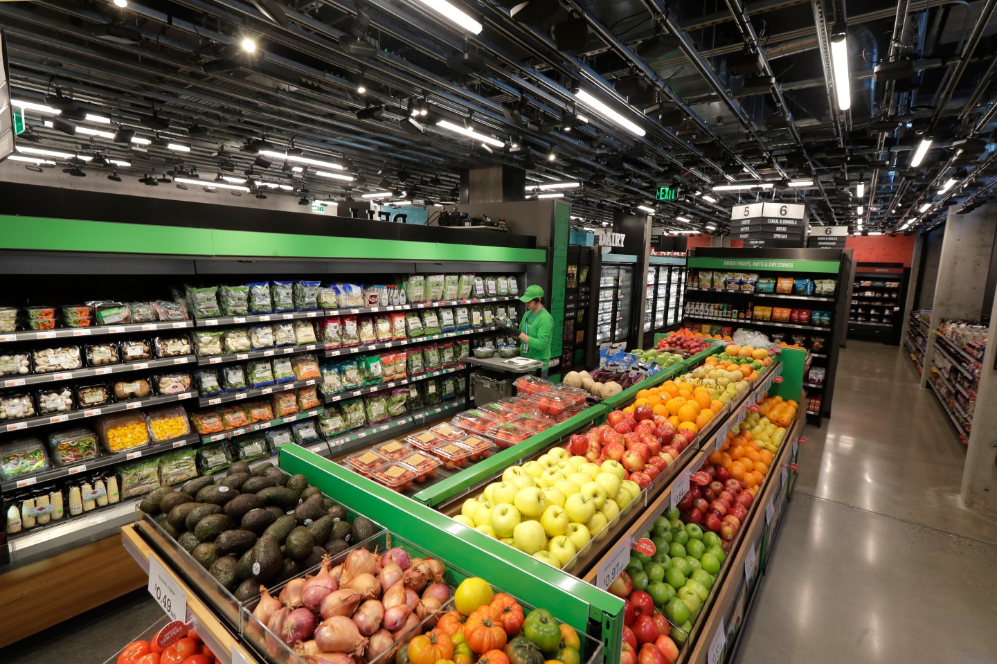 A worker checks items on a shelf in the produce section of an Amazon Go Grocery store set to open soon in Seattle's Capitol Hill neighborhood.