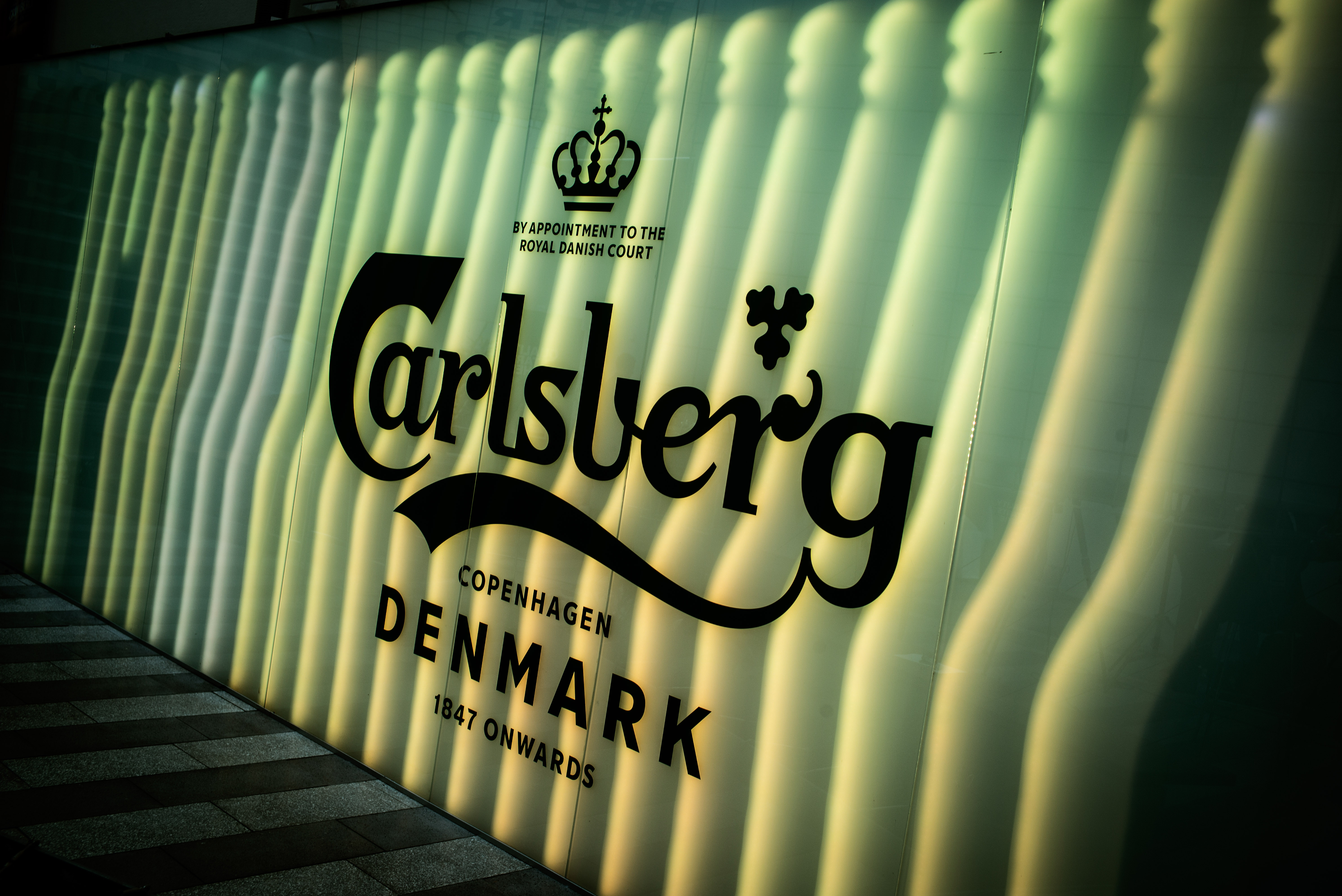 An illuminated logo sits on a wall at the Carlsberg A/S headquarters in Copenhagen, Denmark, in 2019. On Tuesday, Carlsberg reported strong 2019 growth, but warned the coronavirus outbreak is beginning to weigh on operations in its vital China market. Wire Photography: Carsten Snejbjerg—Bloomberg via Getty Images