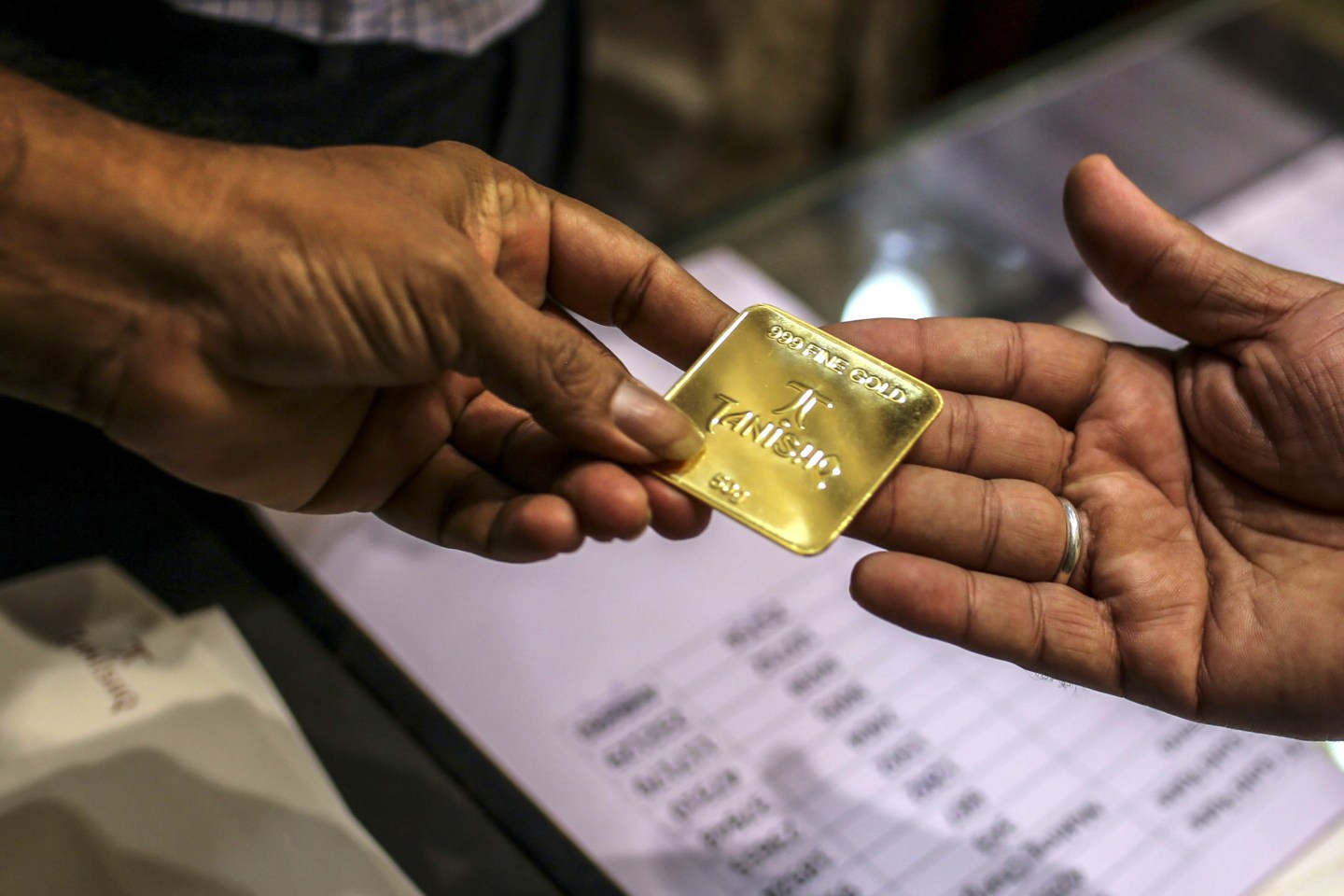 An employee hands a 50-gram gold bar to a customer inside a Titan Co. Tanishq jewelry store during the festival of Dhanteras in Mumbai, India, on Oct. 25, 2019. Gold sales on the most auspicious day in India to buy the metal tumbled this year as high prices and concerns about an economic slowdown saw customers limit purchases. Photographer: Dhiraj Singh/Bloomberg via Getty Images