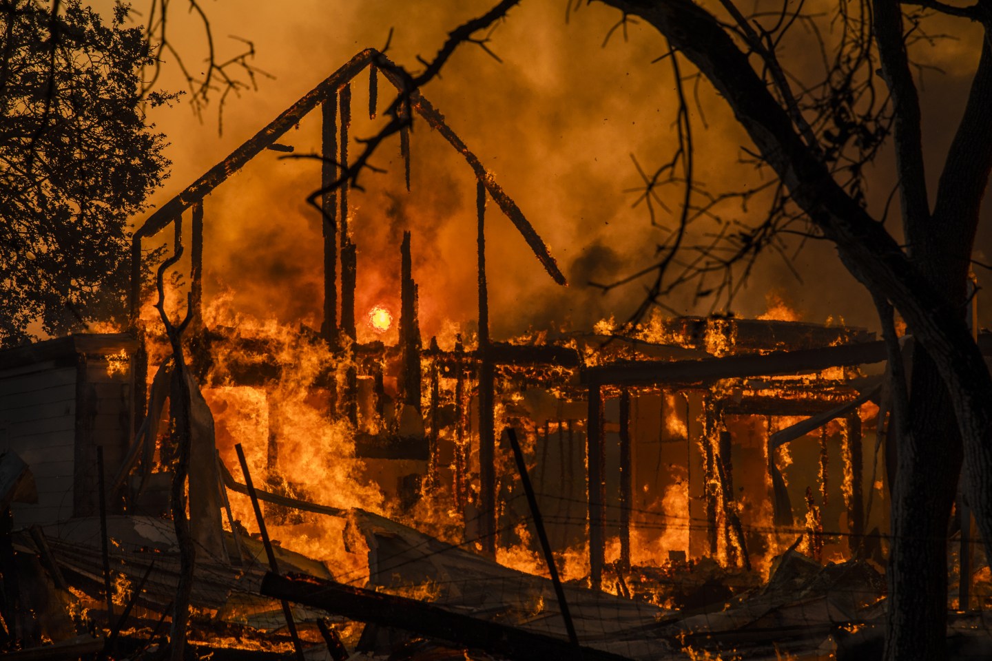 Flames engulf a home as it burns along Highway 128 during the Kincade fire in Healdsburg, California, U.S., on Sunday, Oct. 27, 2019. The wildfire that erupted in California's wine country minutes after a PG&E Corp. power line went down has prompted an expanded evacuation order, as officials warn high winds could drive the blaze toward one of the region's largest towns. Photographer: Phil Pacheco/Bloomberg via Getty Images