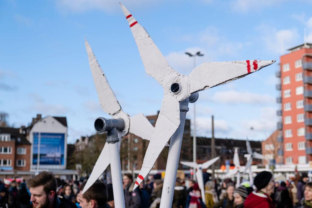 Demonstrators hold cardboard wind turbines in the air during a protest over climate action in Kiel, Germany in November 2019.