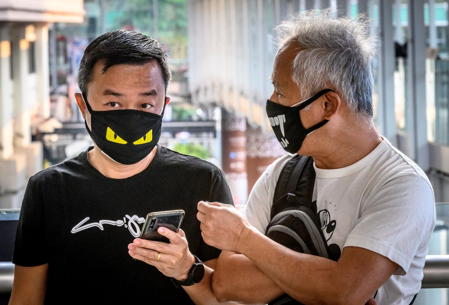 Two men wearing protective facemasks chat on a footbridge in Bangkok on February 3, 2020. - Thailand so far has detected 19 confirmed cases of the novel coronavirus believed to have originated in the central Chinese city of Wuhan, which is under lockdown. (Photo by Mladen ANTONOV / AFP) (Photo by MLADEN ANTONOV/AFP via Getty Images)