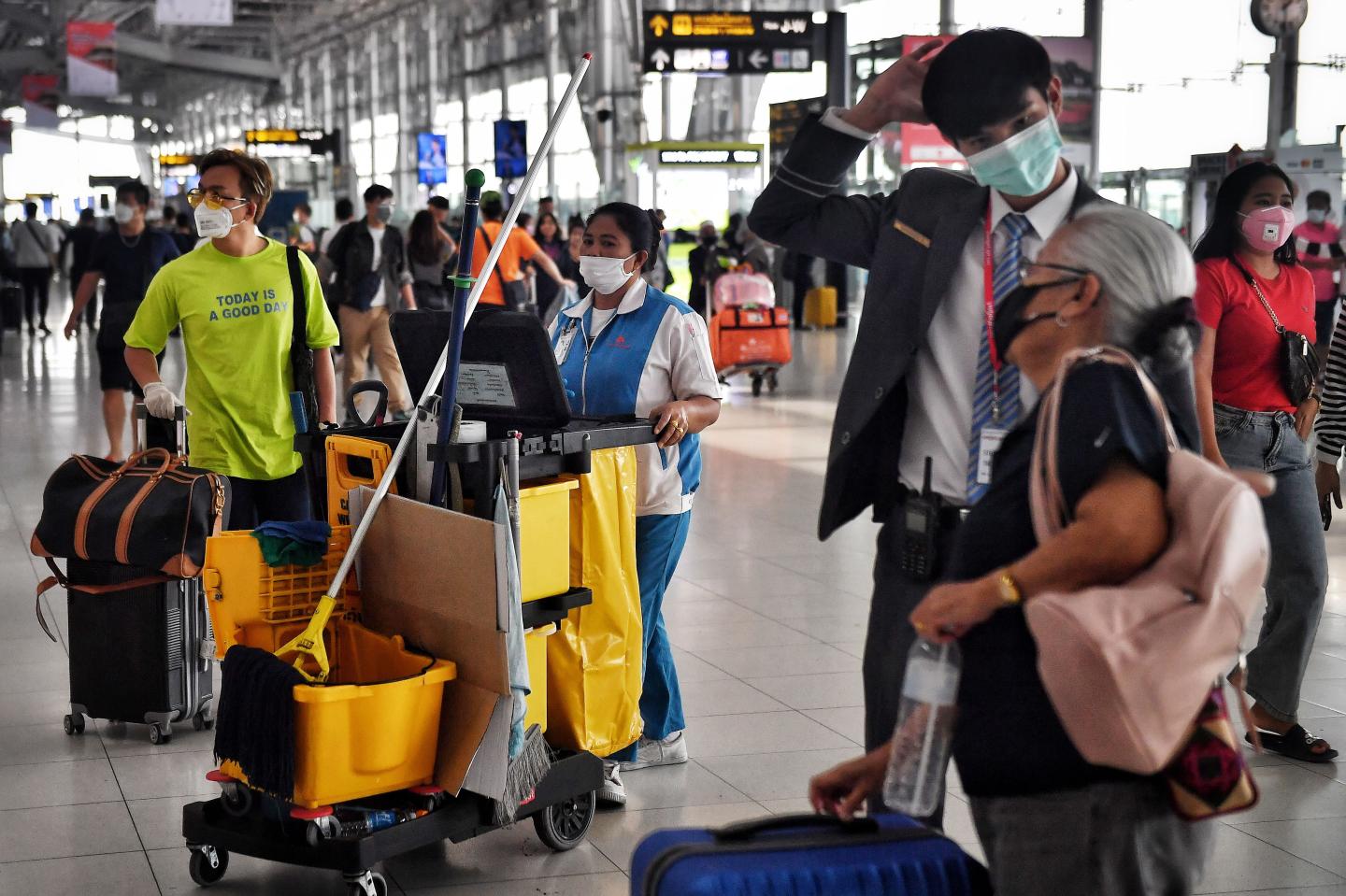 This photo taken on February 5, 2020 shows a cleaner and passengers wearing protective facemasks at Suvarnabhumi International Airport in Bangkok. - Health officials in Vietnam on February 5 said all foreign passport holders -- including from China, Hong Kong and Macau -- that have been to mainland China in the past 14 days will not be permitted to enter Vietnam, in a bid to limit the spread of the novel coronavirus, which is believed to have originated in the central Chinese city of Wuhan. (Photo by Lillian SUWANRUMPHA / AFP) (Photo by LILLIAN SUWANRUMPHA/AFP via Getty Images)