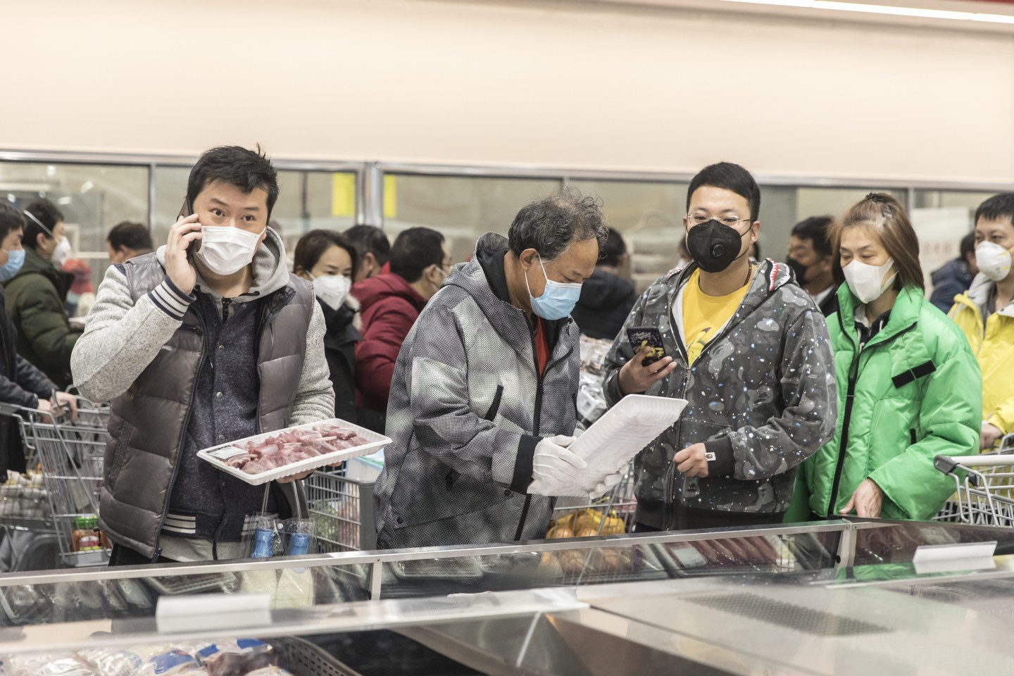Shoppers wearing protective masks select trays of meat at a supermarket in Shanghai, China, on Friday, Feb. 14, 2020. China has upended expectations around the coronavirus epidemic this week with changes to the data and the way cases are diagnosed, forcing a dramatic recalculation of where the country stands in containing the spread. Photographer: Qilai Shen/Bloomberg via Getty Images