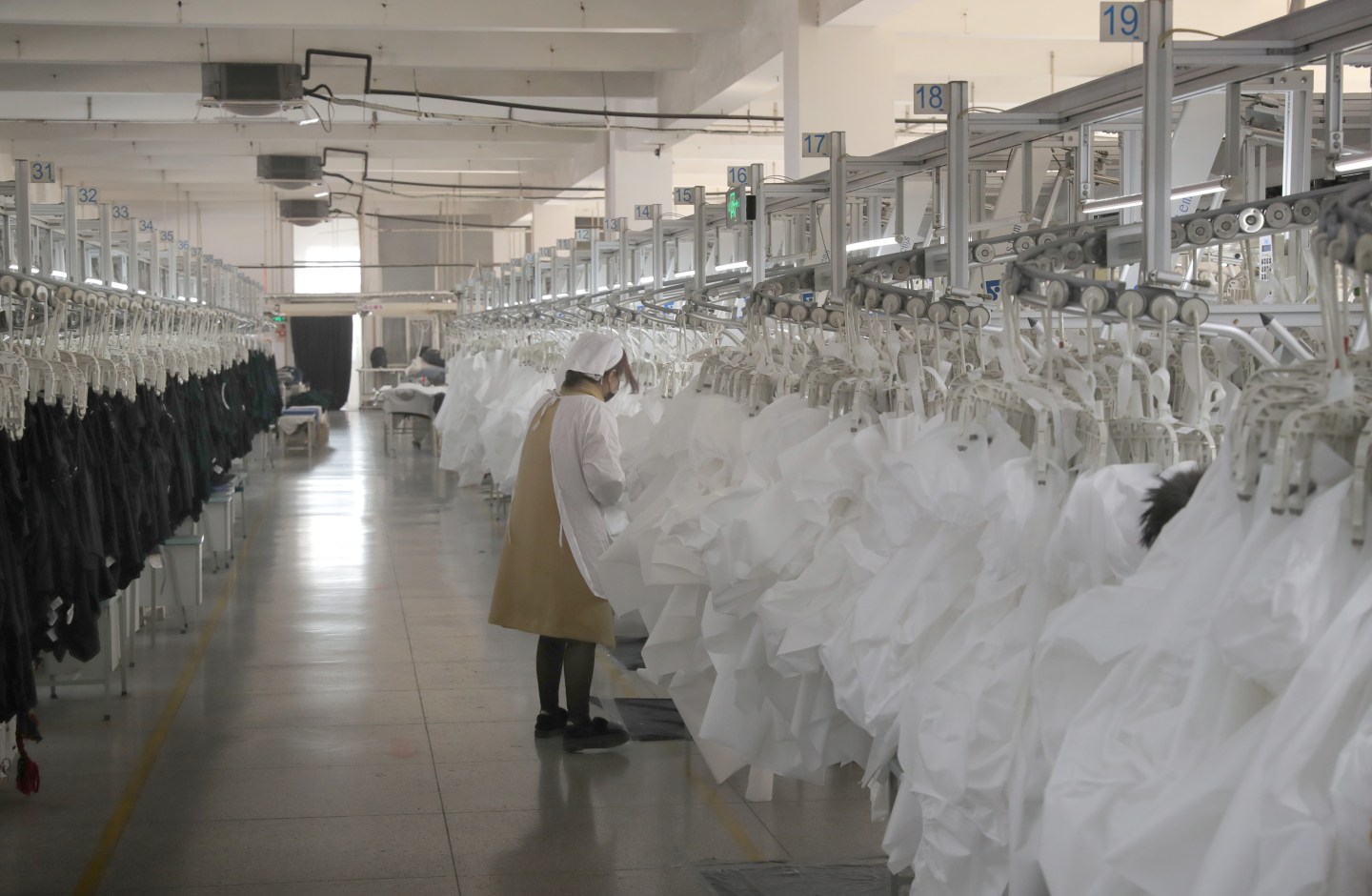 RUGAO, CHINA - FEBRUARY 19 2020: A woman works on isolation gowns in a garment factory in Rugao city in east China's Jiangsu province Wednesday, Feb. 19, 2020.- PHOTOGRAPH BY Feature China / Barcroft Media (Photo credit should read Feature China/Barcroft Media via Getty Images)