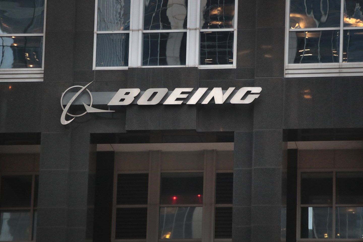 The company logo hangs above an entrance to the headquarters of The Boeing Company on January 29, 2020 in Chicago, Illinois. Boeing said today that costs associated with grounding the 737 Max aircraft were likely to exceed $18 billion. (Photo by Scott Olson/Getty Images)