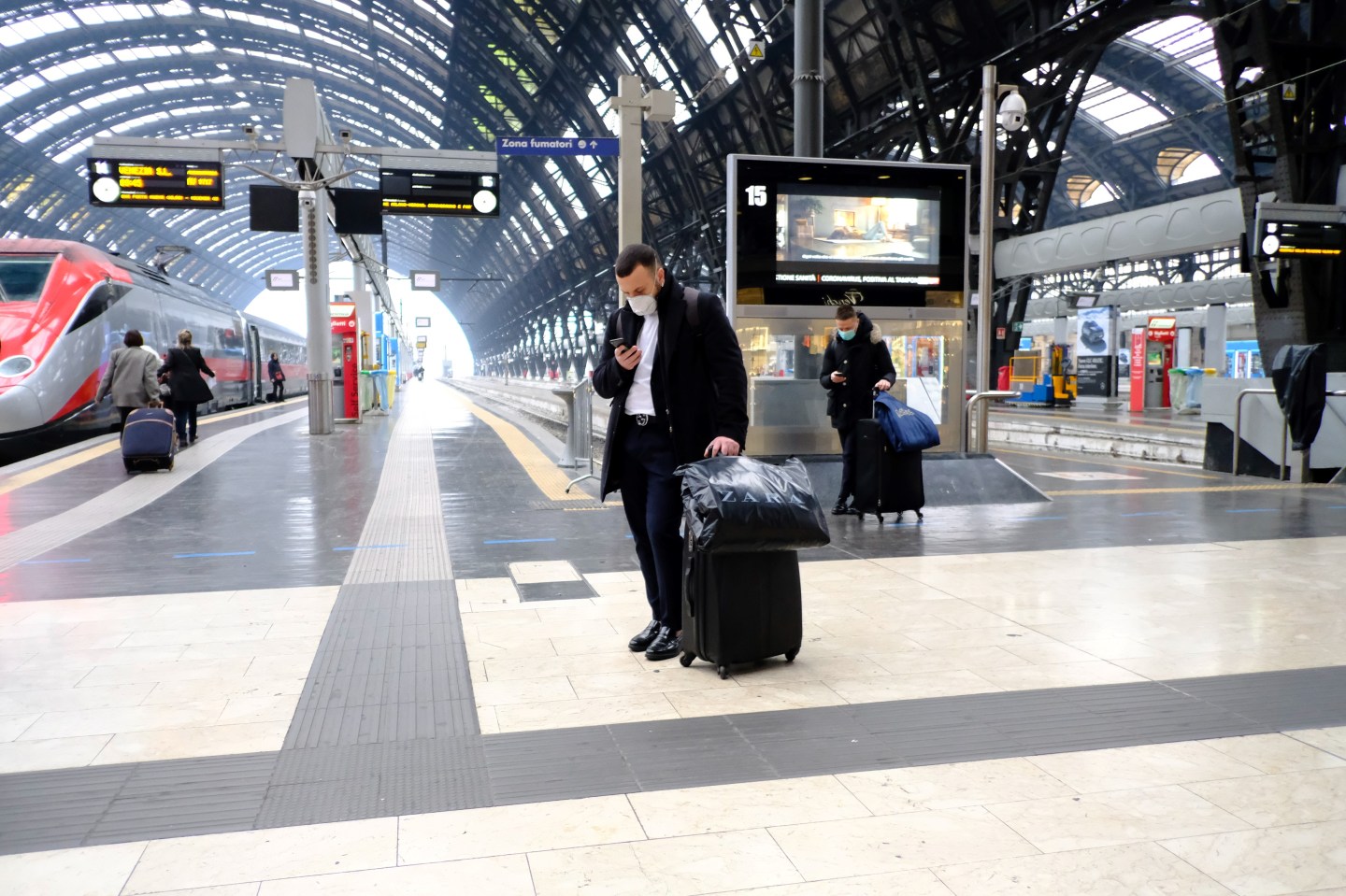 Passengers wearing protective masks wait at Milan's main railway station, on February 25, 2020, following security measures taken in northern Italy against the COVID-19 the novel coronavirus. - Italy reported on February 24, 2020 its fourth death from the new coronavirus, an 84-year old man in the northern Lombardy region, as the number of people contracting the virus continued to mount. (Photo by ANDREAS SOLARO / AFP) (Photo by ANDREAS SOLARO/AFP via Getty Images)
