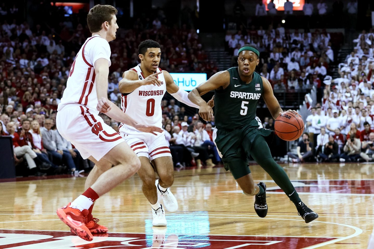 MADISON, WISCONSIN - FEBRUARY 01: Cassius Winston #5 of the Michigan State Spartans dribbles the ball while being guarded by Nate Reuvers #35 and D'Mitrik Trice #0 of the Wisconsin Badgers in the first half at the Kohl Center on February 01, 2020 in Madison, Wisconsin.