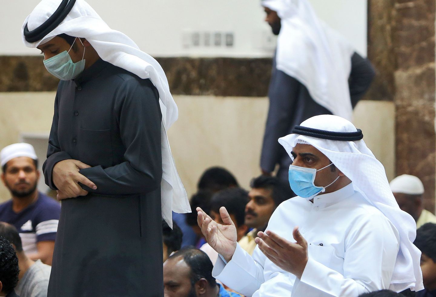 Muslim men wearing protective masks perform Friday prayers at a mosque in Kuwait City on February 28, 2020. - Kuwait's Ministry of Awqaf and Islamic Affairs set the Friday prayer sermon to not exceed 10 minutes, and to discuss precautions against COVID-19 coronavirus disease infections. Kuwait has recorded 43 coronavirus cases since its outbreak, the United Arab Emirates reported 13, while Bahrain has 33, and Oman is at four cases.
