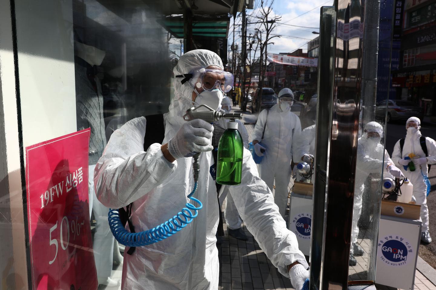 Disinfection professionals wearing protective gear spray antiseptic solution against the coronavirus (COVID-19) on February 27, 2020 in Seoul, South Korea.