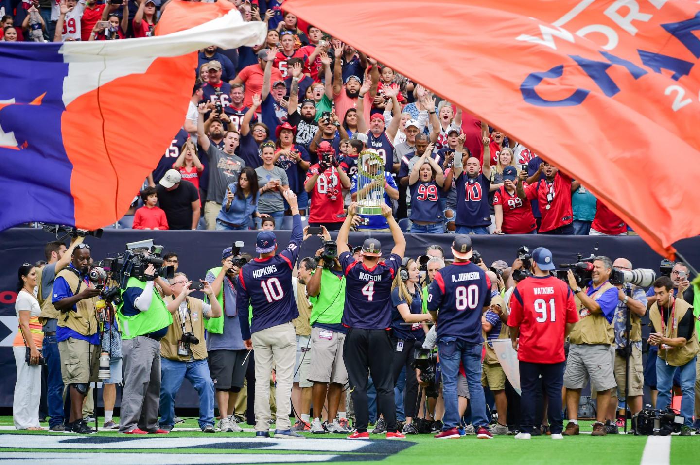 Houston Astros center fielder George Springer (4) hoists the World Series trophy over his head in celebration with Houston fans during the football game between the Indianapolis Colts and the Houston Texans on November 5, 2017 at NRG Stadium in Houston, Texas.