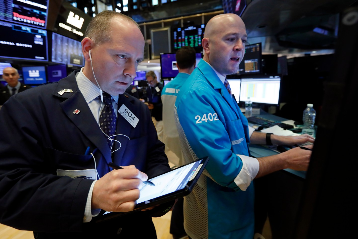 Trader Michael Urkonis, left, and specialist Jay Woods work on the floor of the New York Stock Exchange, Monday, March 2, 2020.