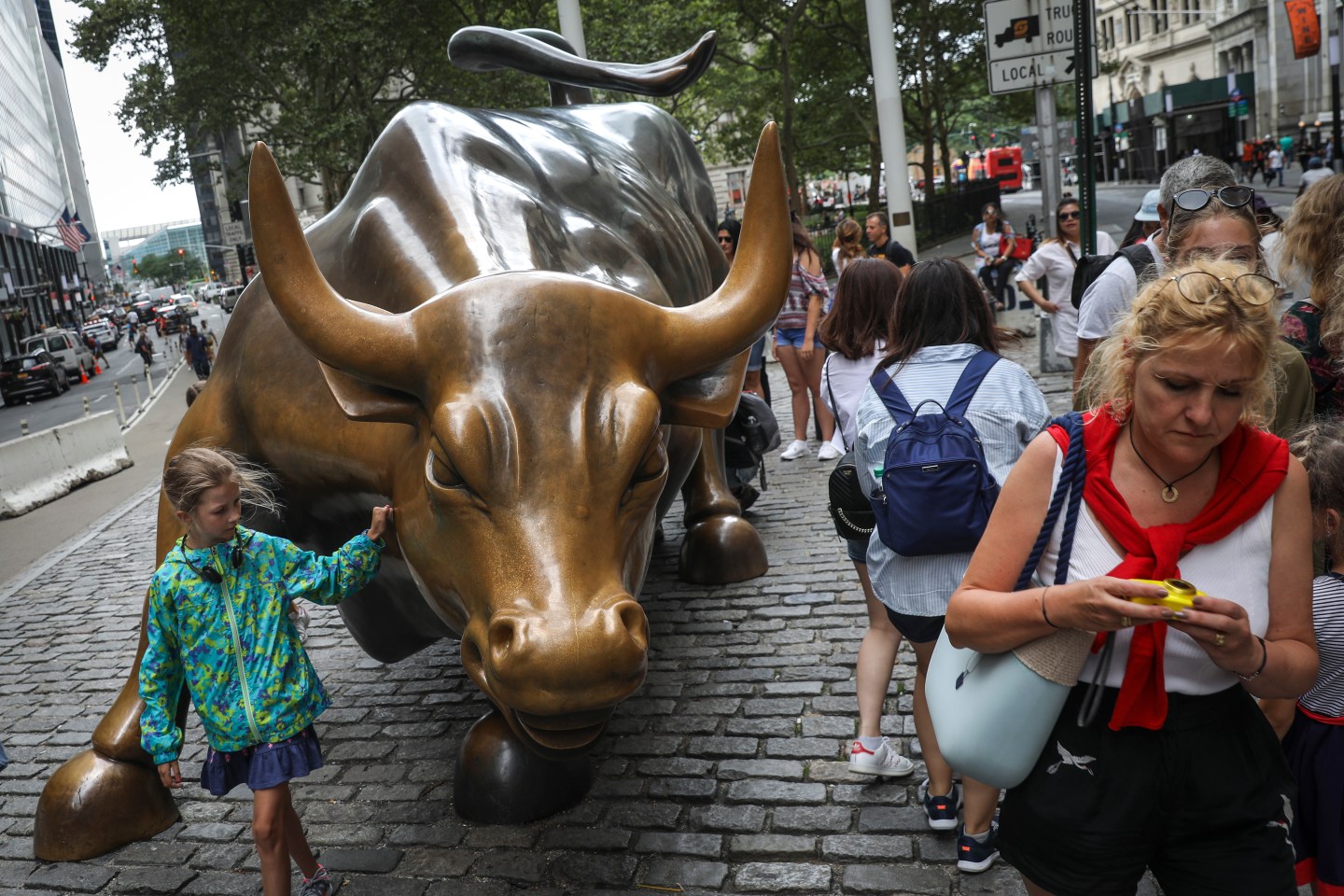 Tourists visit the Wall Street bull statue in the Financial District, August 22, 2018 in New York City.