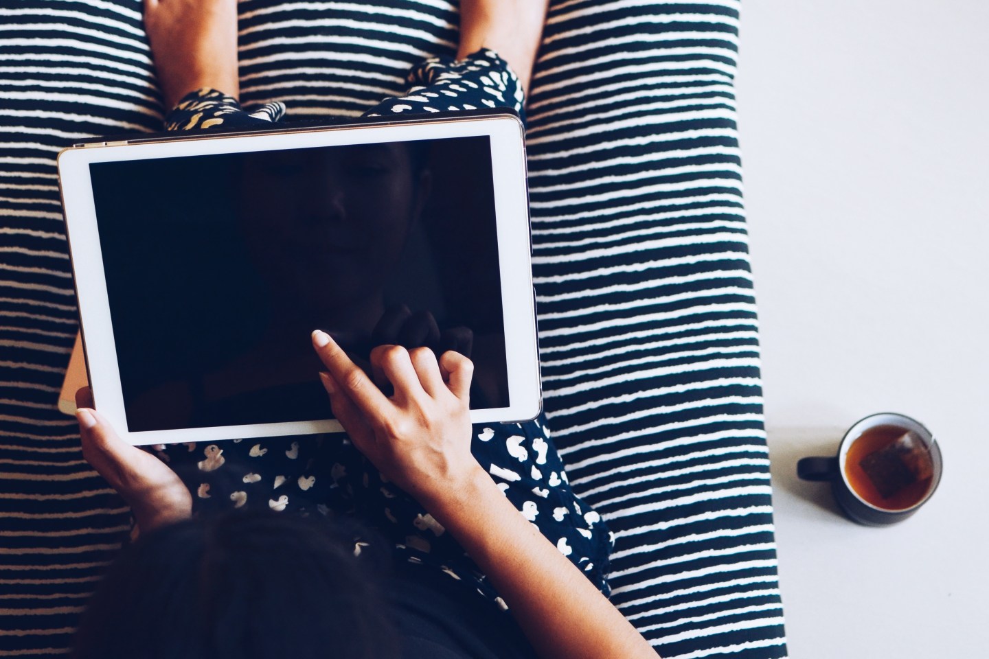 High Angle View Of Woman Using Digital Tablet While Sitting On Sofa At Home