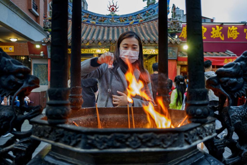 A young woman praying at Xia Hai Da Hai, City God Temple in