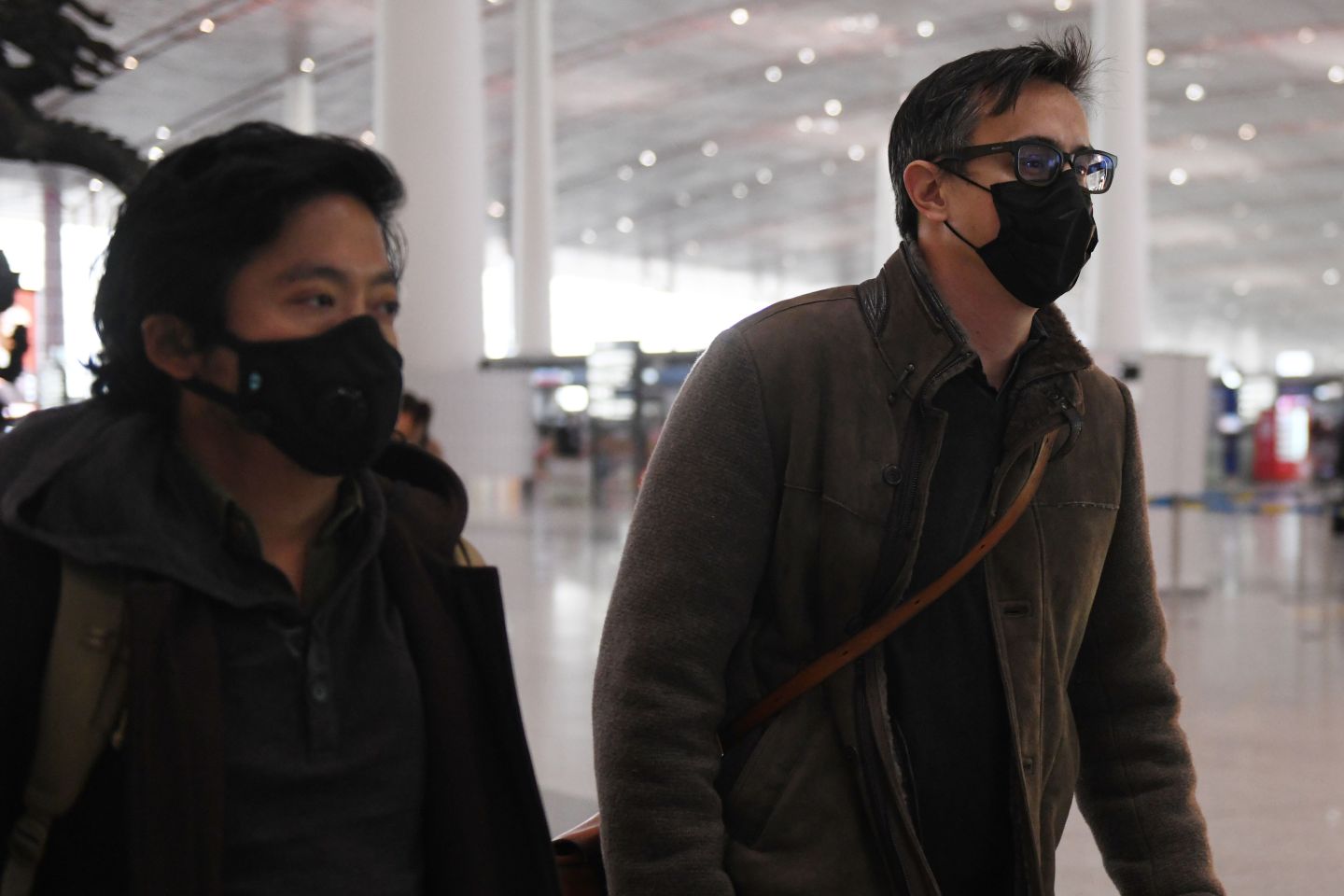 Wall Street Journal reporters Josh Chin (R) and Philip Wen walk through Beijing Capital Airport before their departure on February 24, 2020. - Two Wall Street Journal reporters left China on February 24 after being expelled over a controversial headline in an op-ed that angered Beijing. Three reporters were ordered out of the country last week over what Beijing deemed a racist headline that the journalists were not involved in writing -- marking one of the harshest moves against foreign media in years. (Photo by GREG BAKER / AFP) (Photo by GREG BAKER/AFP via Getty Images)