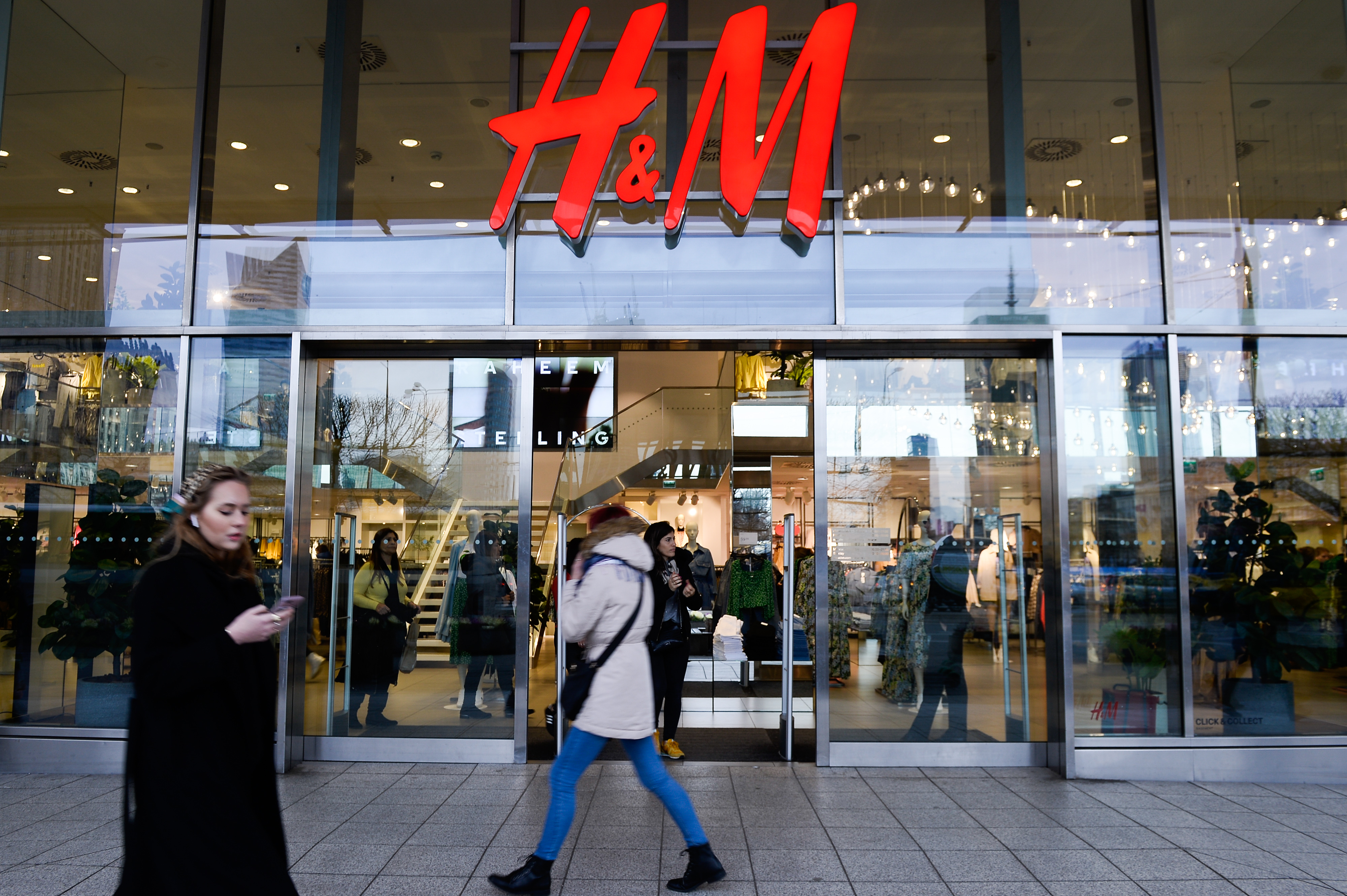 WARSAW, POLAND - 2020/03/03: People walk past a H&amp;M clothing store at the city center.