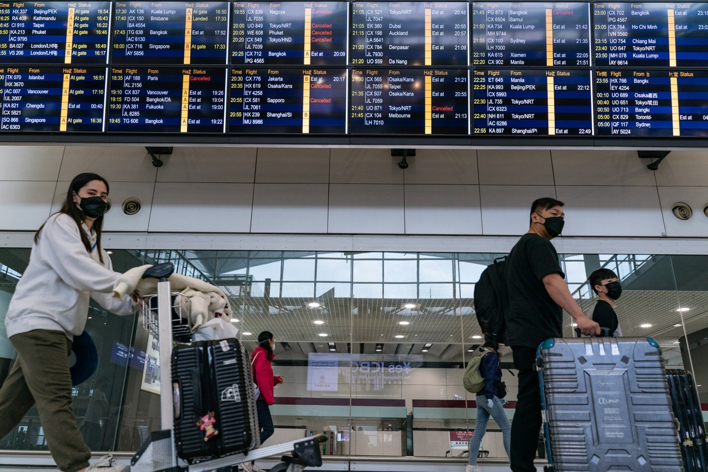 HONG KONG, CHINA - MARCH 10: Travellers wearing masks walk at the arrival hall of the Hong Kong International Airport on March 10, 2020 in Hong Kong, China. Hong Kong's government announced all travellers returning from Italy, some parts of France, Germany, and Japan will be put under mandatory quarantine. (Photo by Anthony Kwan/Getty Images)