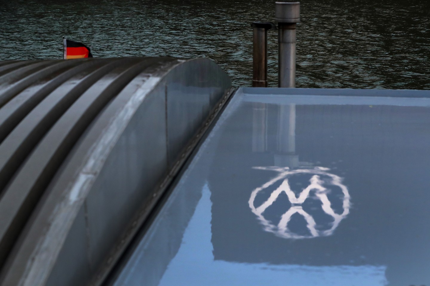 The Volkswagen AG (VW) logo sits reflected on the window of a docked barge on the River Aller in Wolfsburg, Germany, on Thursday, March 12, 2020. The outlook is darkening for everyone from market leader Volkswagen AG to Tesla Inc. and smaller local contenders that were already battling an unprecedented slump before the coronavirus outbreak.