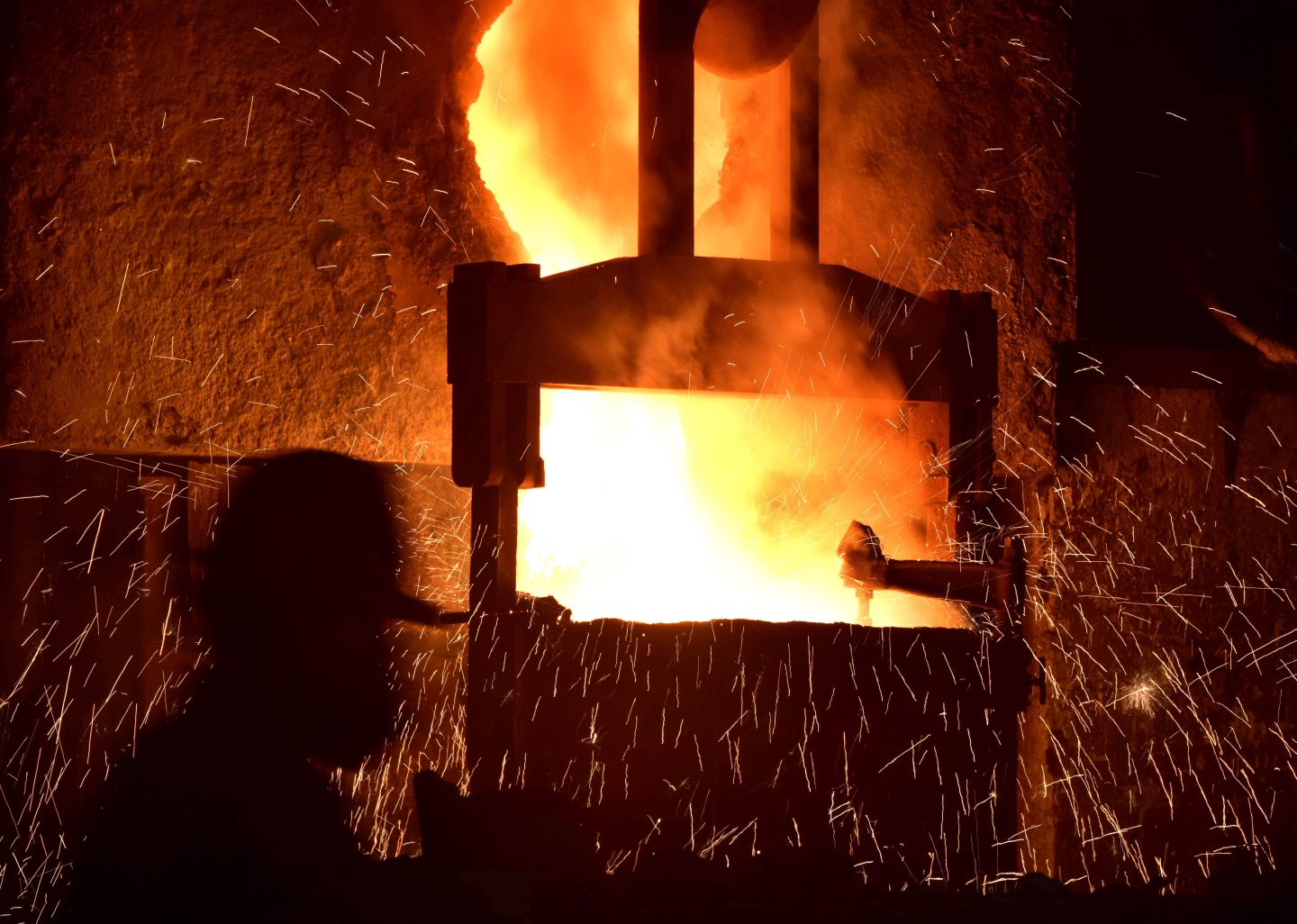 This photo taken on March 15, 2020 shows a worker walking past molten steel at a foundry in Wuyi, China's eastern Zhejiang province. - China's industrial production, retail sales and investment all contracted in the first two months of the year after the coronavirus epidemic wreaked havoc on the economy, official data showed on March 16. (Photo by STR / AFP) / China OUT (Photo by STR/AFP via Getty Images)