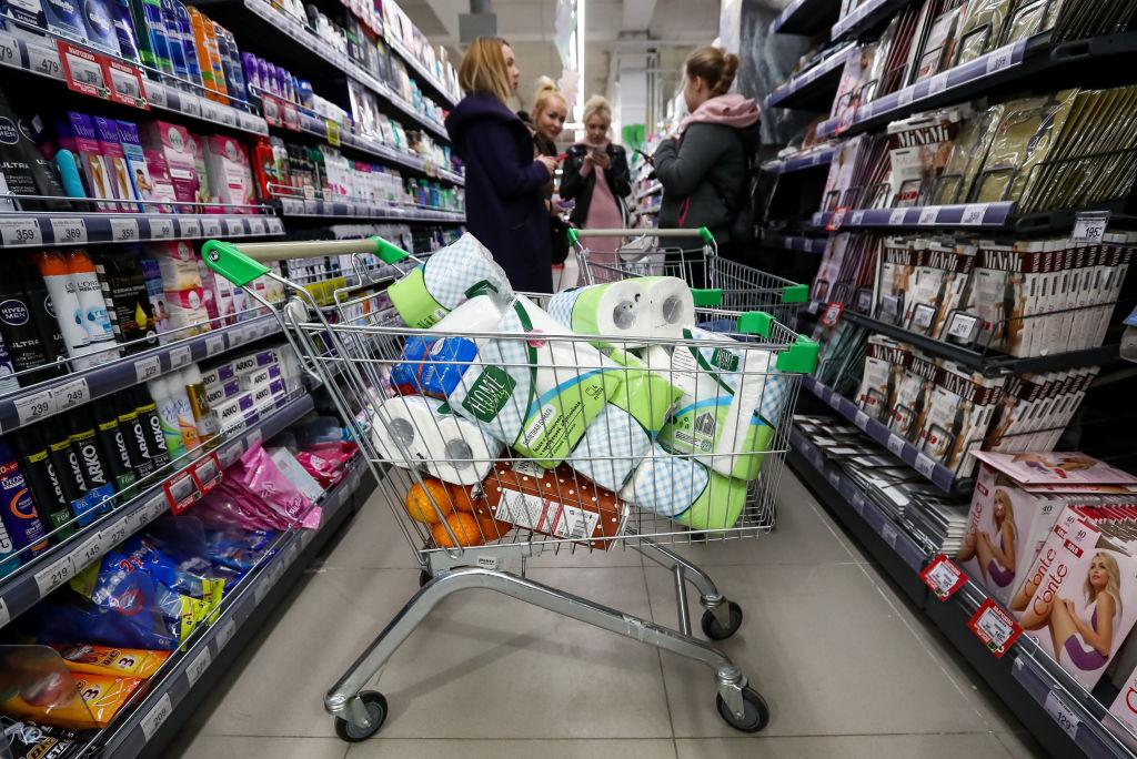 A shopping cart full of toilet paper rolls.