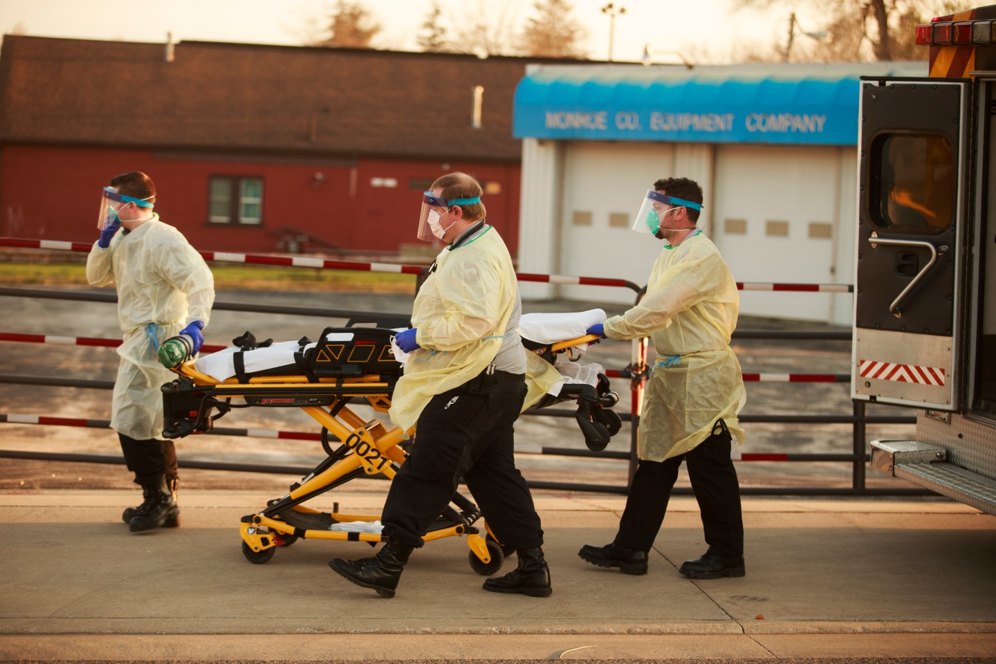 BLOOMINGTON, UNITED STATES - MARCH 23, 2020: First responders from IU Health Bloomington hospital pick up a woman at the corner of 1st St and S. Walnut St who was sitting slumped over, and was saying she was having trouble breathing, and other COVID-19/Coronavirus symptoms in Bloomington, Ind. Police officers stood by after making first contact with the woman before emergency workers arrived in personal protective equipment to help the woman, putting her on a stretcher, and loading her into an ambulance.- PHOTOGRAPH BY Jeremy Hogan / Echoes Wire/ Barcroft Studios / Future Publishing (Photo credit should read Jeremy Hogan / Echoes Wire/Barcroft Media via Getty Images)