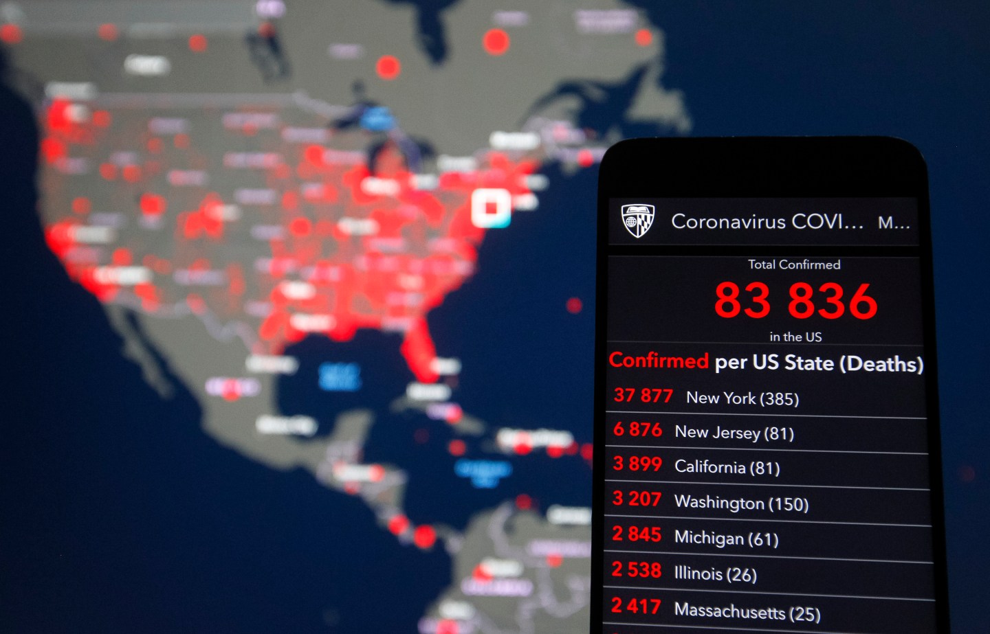 KIEV, UKRAINE - 2020/03/27: In this photo illustration the Coronavirus COVID-19 Global Cases map by the Center for Systems Science and Engineering (CSSE) at Johns Hopkins University (JHU) is seen displayed in internet on a mobile phone and a pc screen. The U.S. leads the world in confirmed COVID-19 coronavirus cases, according to media as of 27 March 2020. The World Health Organization declared the coronavirus a global pandemic on 11 March 2020. (Photo Illustration by Pavlo Gonchar/SOPA Images/LightRocket via Getty Images)