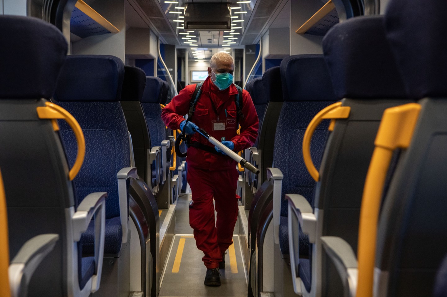 MILAN, ITALY - MARCH 04: A utility service worker, wearing a face mask, deep cleans a Trenord train as a measure to prevent the spread of the SARS-CoV-2 (aka Coronavirus) at Porta Garibaldi train station on March 04, 2020 in Milan, Italy. Across Italy 2.502 people were infected by the novel Coronavirus so far (among these 79 people died - mainly because of a previous and serious clinical picture compromised by the virus-, 2263 people are currently positive and 160 people already recovered). The spread marks Europe’s biggest outbreak, prompting Italian Government to issue draconian safety measures. (Photo by Emanuele Cremaschi/Getty Images)