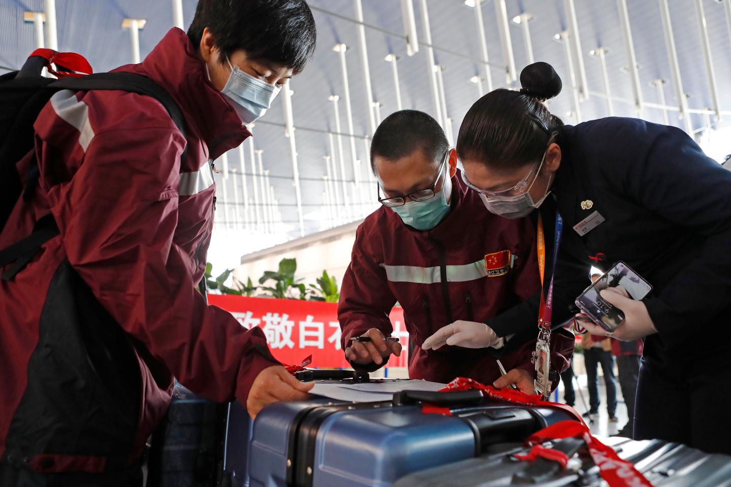 SHANGHAI, CHINA - MARCH 18: Anti-epidemic medical experts check in at waiting hall of Shanghai Pudong International Airport as they leave for Italy on March 18, 2020 in Shanghai, China. An anti-epidemic medical expert team of 13 people as wells as 17.3 tons of anti-epidemic supplies, departed on Wednesday from China's Shanghai for Milan to help contain novel coronavirus outbreak in Italy. (Photo by Yin Liqin/China News Service via Getty Images)
