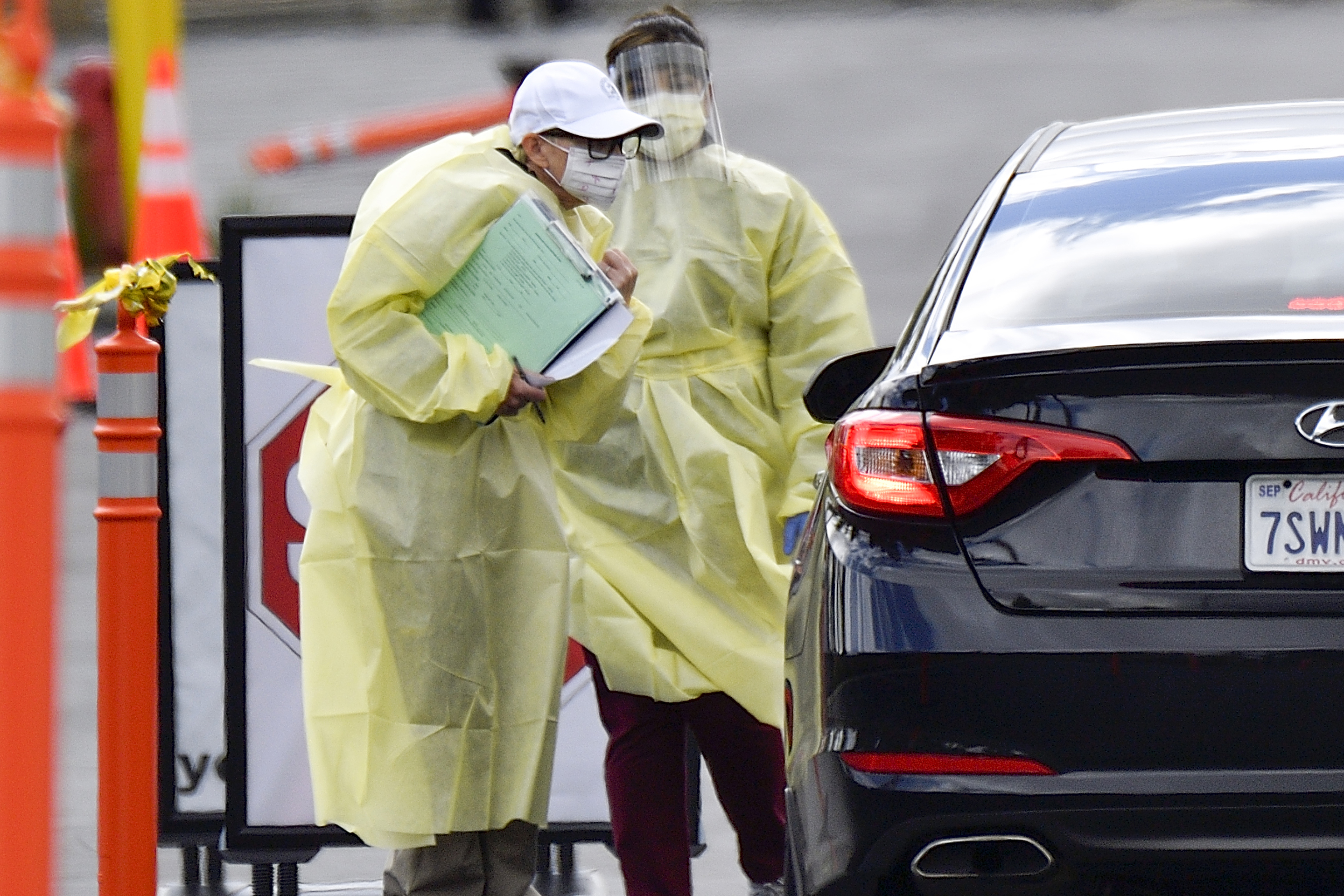 A healthcare worker interviews people after at a drive through coronavirus (COVID-19) screening at St. Joseph Heritage Medical Group in Yorba Linda, CA, on Thursday, March 19, 2020.
