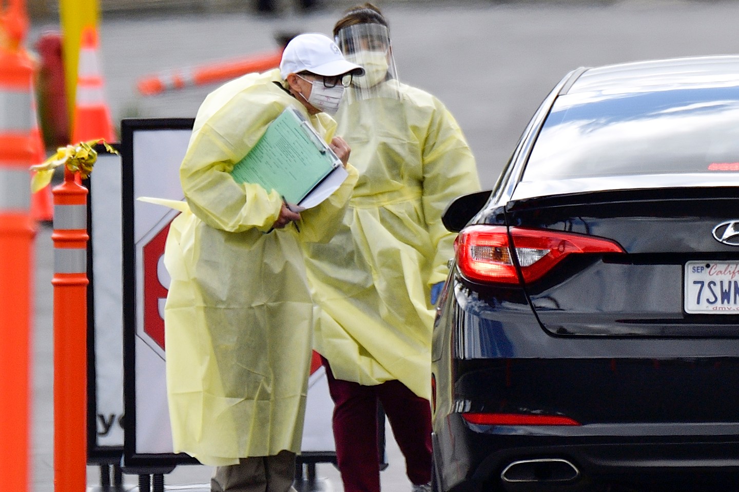 A healthcare worker interviews people after at a drive through coronavirus (COVID-19) screening at St. Joseph Heritage Medical Group in Yorba Linda, CA, on Thursday, March 19, 2020.