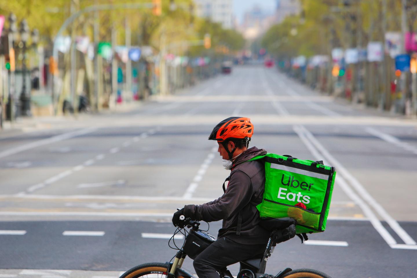 BARCELONA, SPAIN - MARCH 22: A cyclist Uber delivery rides his bike at Passeig de Gracia boulevard empty of visitors, tourists and no traffic on March 22, 2020 in Barcelona, Spain. The coronavirus (COVID-19) pandemic has spread to at least 182 countries, claiming over 10,000 lives and infecting hundreds of thousands more. (Photo by Miquel Benitez/Getty Images)