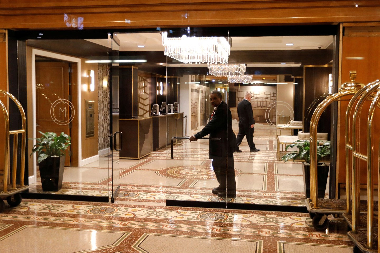 A doorman looks out from an empty hotel lobby in Herald Square in Manhattan during the coronavirus outbreak (COVID-19) in New York City, New York, U.S., March 18, 2020.