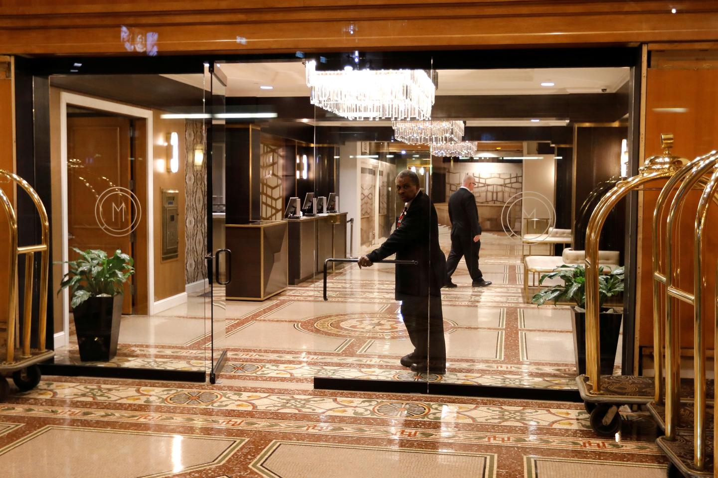 A doorman looks out from an empty hotel lobby in Herald Square in Manhattan during the coronavirus outbreak (COVID-19) in New York City, New York, U.S., March 18, 2020.