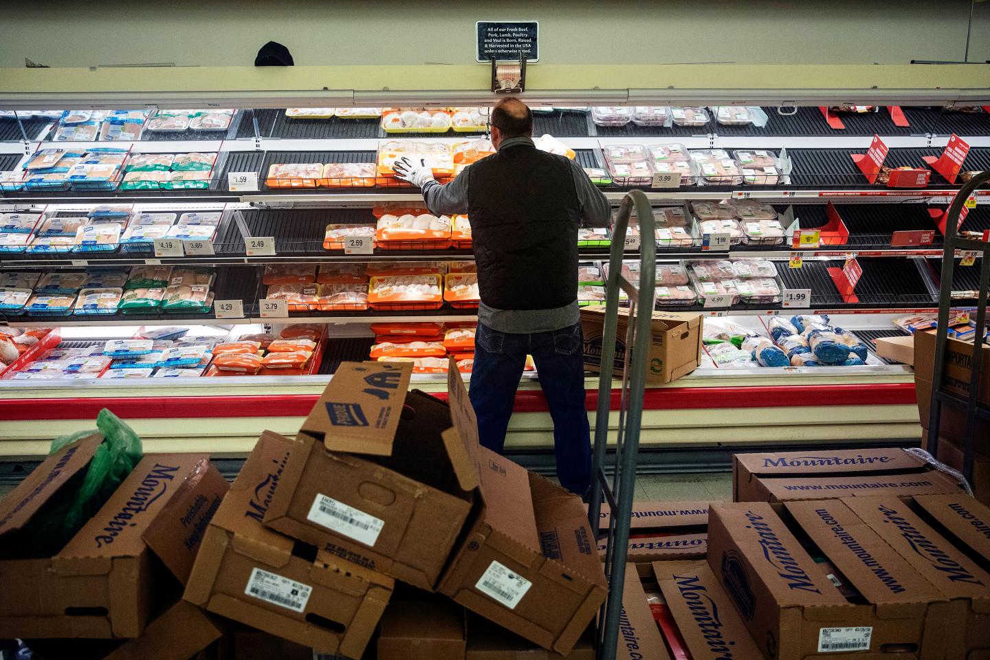A worker restocks the meat section of a Stop & Shop supermarket during hours open daily only for seniors Thursday, March 19, 2020, in North Providence, R.I.
