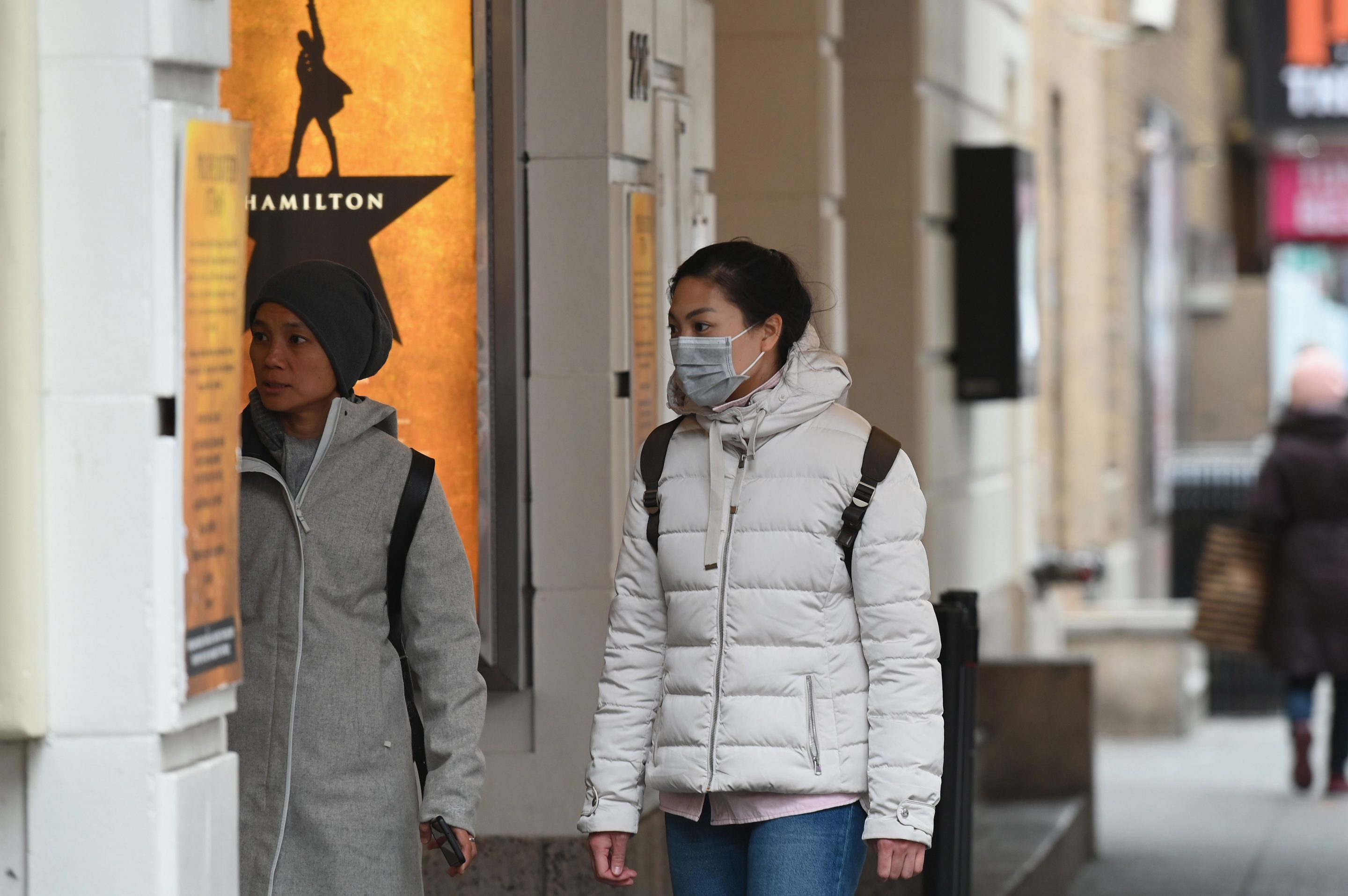 A woman walks by "Hamilton: An American Musical" on Broadway on March 12, 2020 in New York City. New York Governor Andrew Cuomo banned public gatherings of more than 500 people, including shows in Manhattan's iconic Broadway theater district.