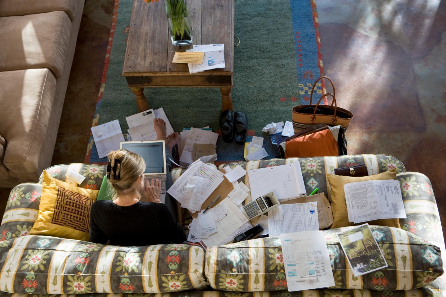 A woman works from her couch at home.