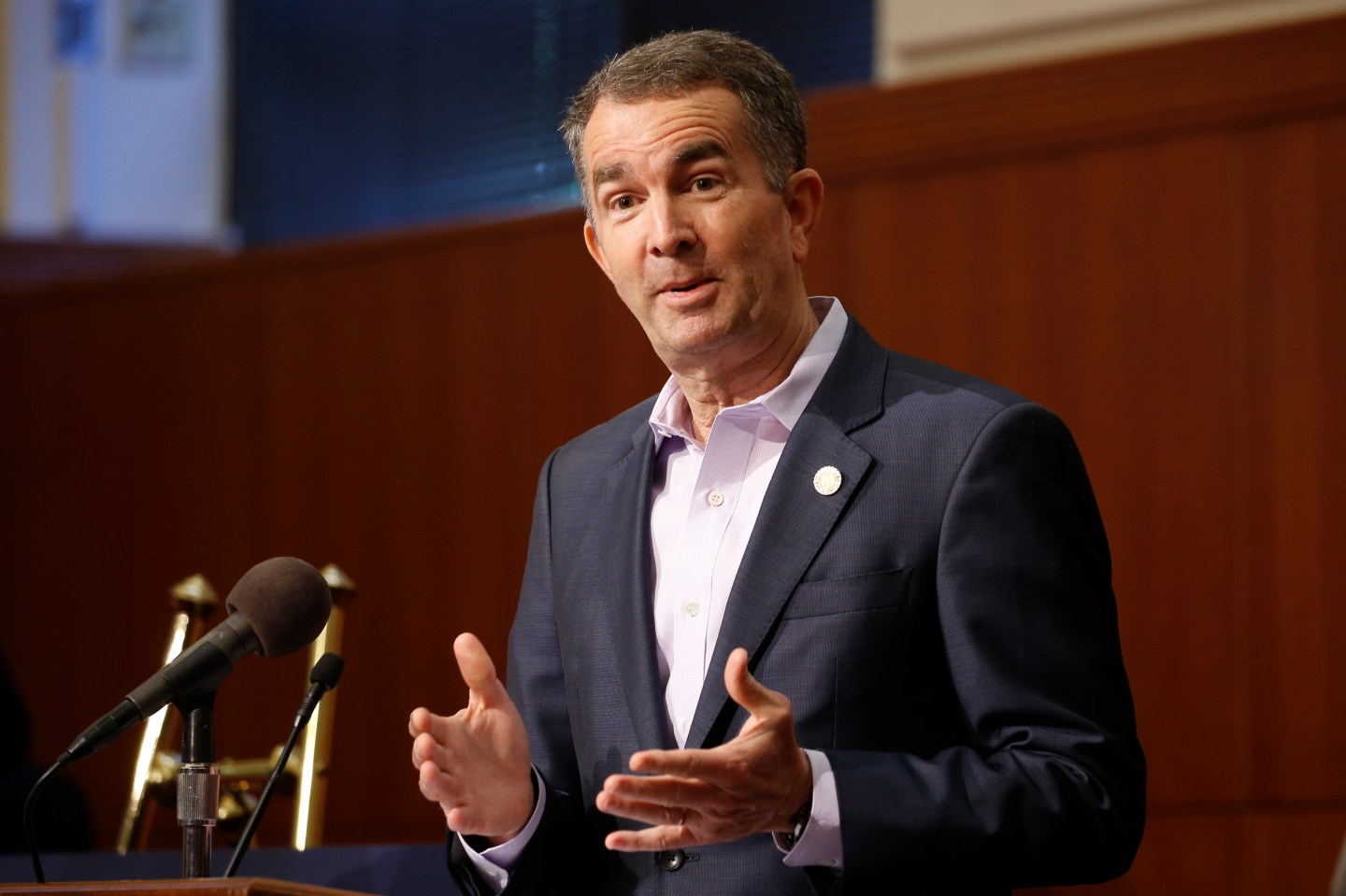 FILE - In this April 8, 2020 file photo, Virginia Gov. Ralph Northam gestures during a news conference at the Capitol in Richmond, Va. Gov. Northam announced Friday, April 10 that he'd signed bills that include requiring universal background checks on gun purchases, a red flag bill to allow authorities to temporarily take guns away from people deemed to be dangerous to themselves or others, and legislation giving local governments more authority to ban guns in public places. (AP Photo/Steve Helber, File)