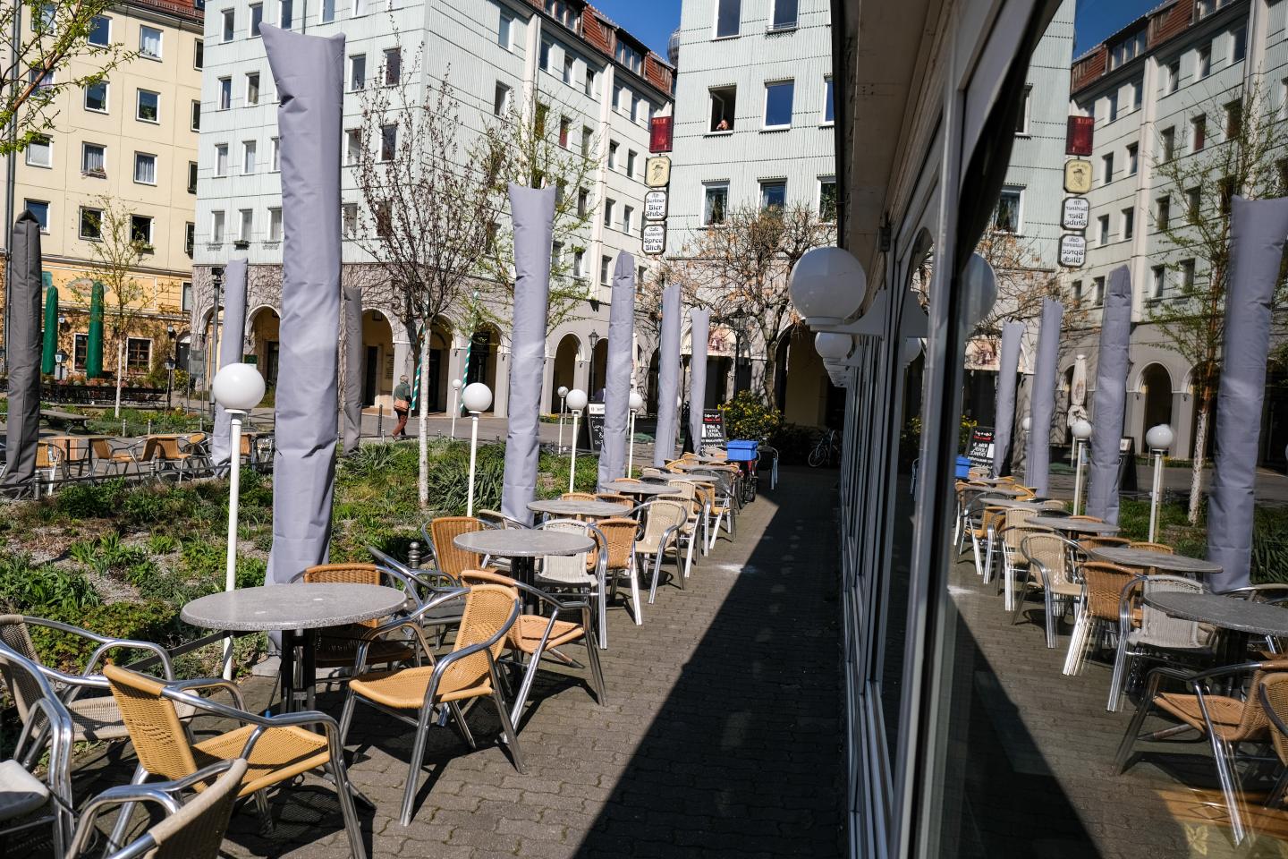 06 April 2020, Berlin: Unoccupied tables and chairs from closed cafés and restaurants are reflected in the Nikolai quarter in Propststraße. This is actually a tourist hotspot, which is populated by numerous people. Because of the Corona epidemic, restaurants are only allowed to offer take-away food.
