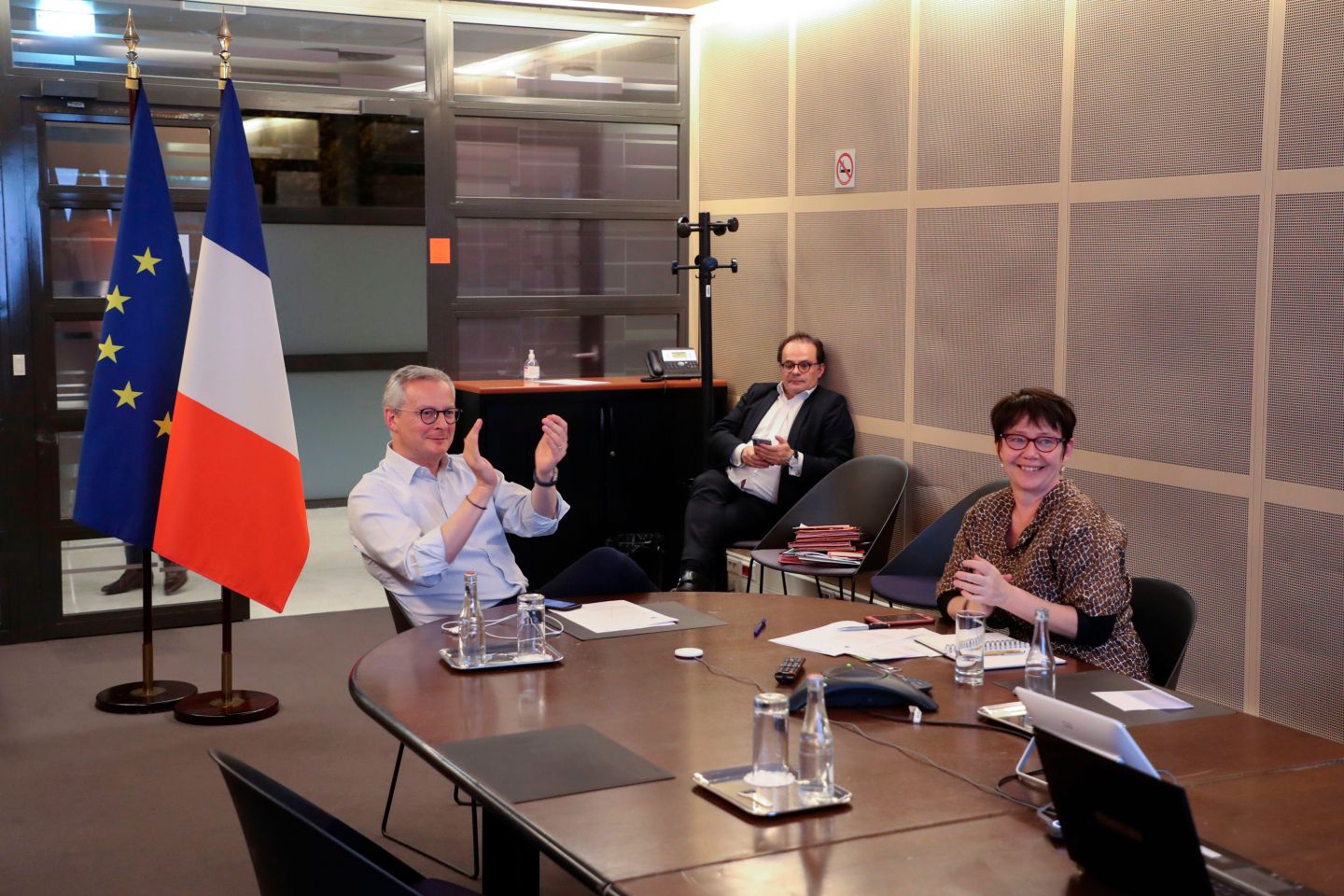 French Economy Minister Bruno Le Maire (L) applauses past French Treasury managing director Odile Renaud-Basso (R) as they attend an EU finance ministers meeting by videoconference, at the minister's office in Paris on april 9, 2020, on the twenty-fourth day of a strict lockdown aimed at curbing the spread of COVID-19, the novel coronavirus. - EU finance ministers agreed a 500-billion-euro ($550-billion) rescue on April 9, 2020 for European countries hit hard by the coronavirus epidemic, but sidelined a demand by Italy and France for pooled borrowing. (Photo by Ludovic MARIN / AFP) (Photo by LUDOVIC MARIN/AFP via Getty Images)