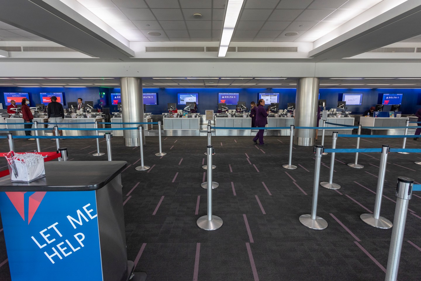 Employees at the Delta Air Lines counters wait for customers at a nearly deserted Los Angeles International Airport due to the coronavirus pandemic on April 16, 2020 in Los Angeles, California. Passenger air travel has plummeted more than 90 percent at LAX as airlines slash flights and consolidate operations since COVID-19 has forced most travelers to stay home.