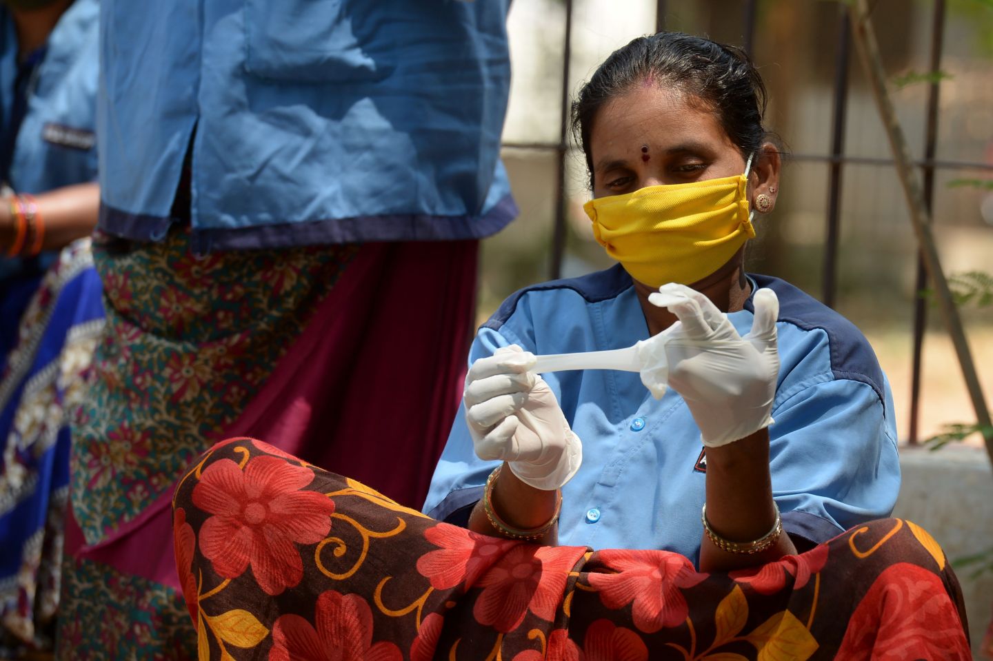 A street sweeper tries gloves distributed by the Directorate of Medical and Health Unit during a government-imposed nationwide lockdown as a preventive measure against the COVID-19 coronavirus, in Hyderabad on April 22, 2020. (Photo by NOAH SEELAM / AFP) (Photo by NOAH SEELAM/AFP via Getty Images)