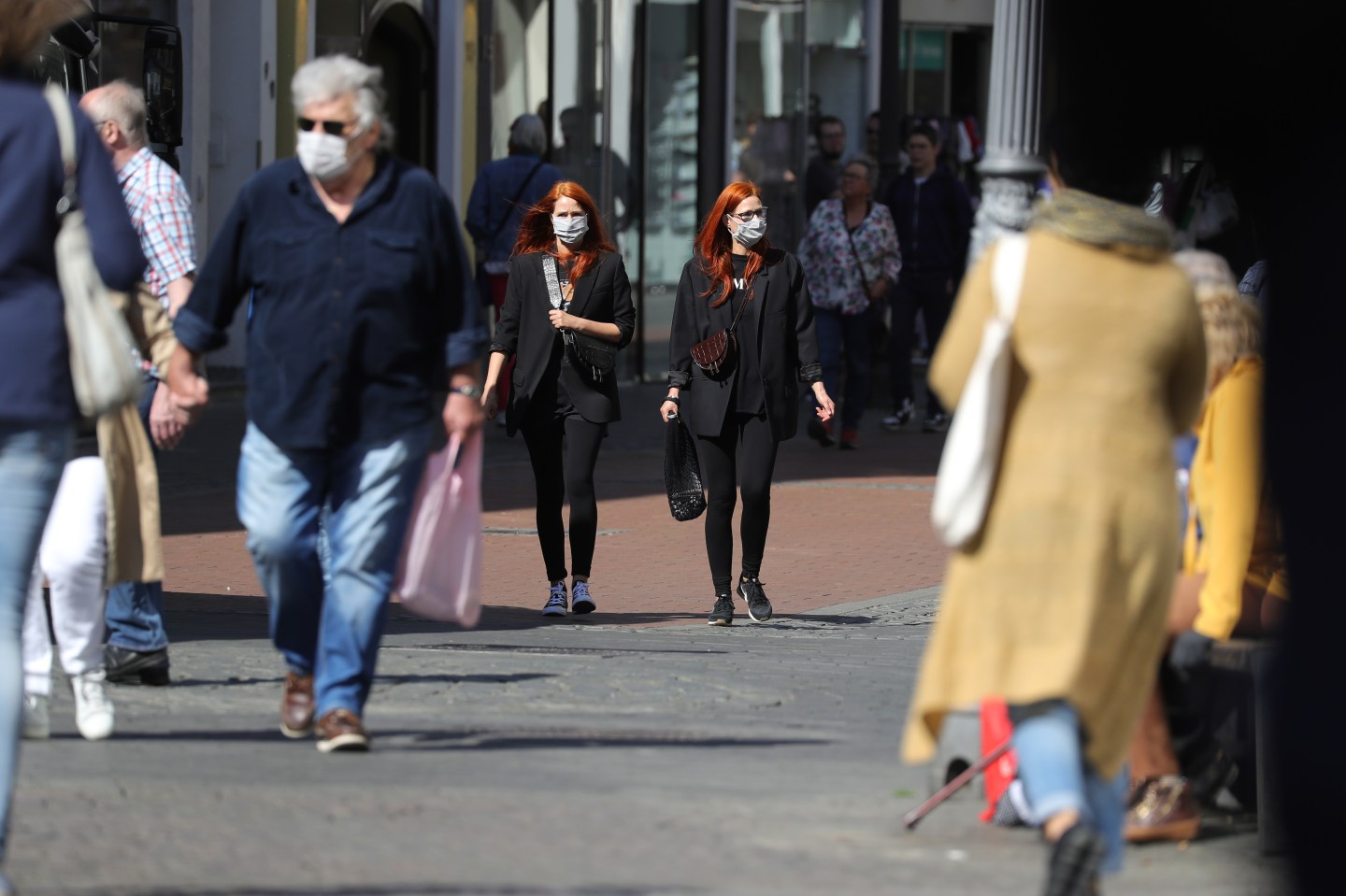 Customers wearing protective face masks seen shopping in the streets on the first day of the easing of some restrictions during the coronavirus crisis on April 20, 2020 in Bonn, Germany.