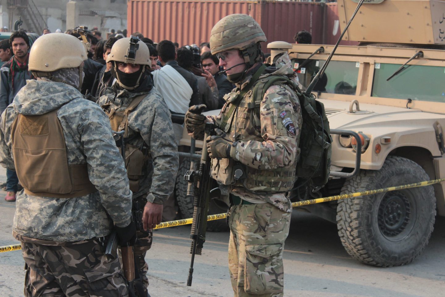 US soldiers inspect a damaged vehicle on a tow truck at the scene of a suicide bomb attack that targeted the vehicle of European Union Police Mission in Afghanistan, in Kabul, January 2015.