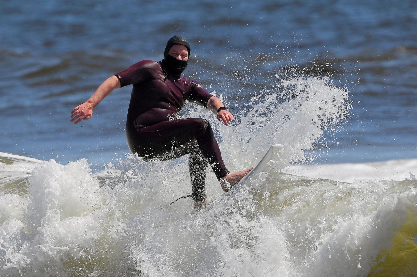 Tim O'Rourke surfs with a face covering to protect him from the coronavirus at Venice Beach, during the coronavirus outbreak in Los Angeles.  Mark J. Terrill—AP Photo